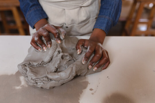Close up of a mixed race female potter working in pottery studio