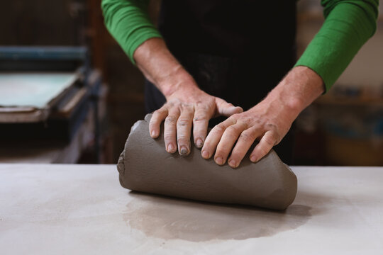 Close up of a caucasian male potter working in pottery studio