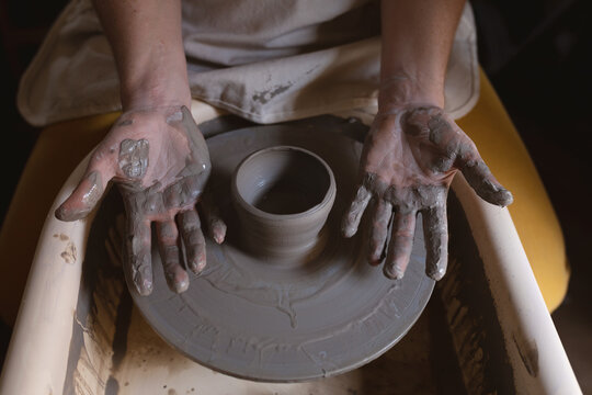 Caucasian female potter in face mask working in pottery studio