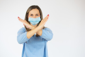 Woman wearing surgical mask in casual sweater say no on white background