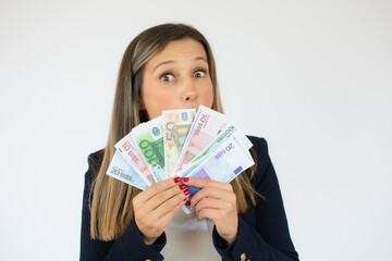 Close up portrait of a exciting young business woman holding money banknotes and celebrating isolated over white background