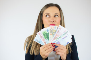 Close up portrait of a young business woman holding money banknotes and celebrating isolated over white background