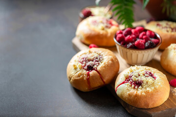 Homemade Sweet Yeast Buns filled with Berry and with crumble on a black background.