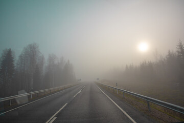 Poor visibility. The road is in heavy fog, along the edges of the road there is a forest. Autumn...