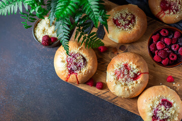 Naklejka na ściany i meble Homemade Sweet Yeast Buns filled with Berry and with crumble on a black background.