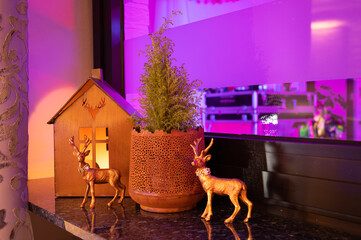 Modern christmas decoration with rusty miniature house and deer in cozy atmosphere