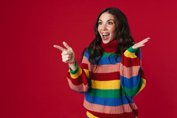 Excited beautiful girl holding copyspace and pointing finger aside