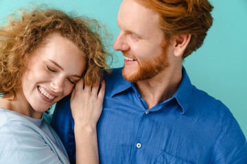 Young happy redhead couple hugging and laughing at camera