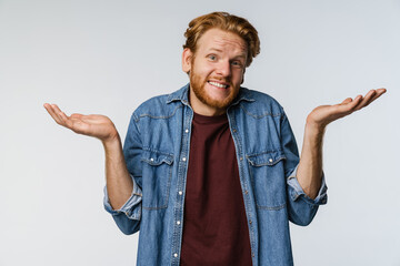 Pleased unshaven redhead guy posing and looking at camera