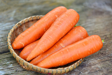 carrot on basket, fresh carrot for cooking vegetarian on wooden table in the kitchen.