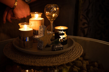 Modern wooden christmas decorations on a concrete dish with candles and glittery hourglass