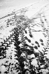 Tracks in snow. Tire tracks and footprints. Black and white background