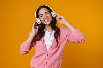 Joyful girl listening music with wireless headphones and smiling