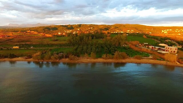 Aerial view of Pylos bay, Peloponnese, Greece, at golden dusk with clouds lit by the setting sun.