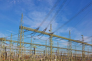 Picture of a transformer station with many insulators and cables during the day