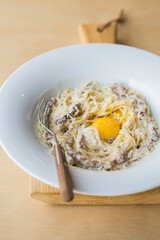 Spaghetti Carbonara on wooden table. Classic homemade carbonara pasta with pancetta. Carbonara pasta, spaghetti with bacon,egg,cheese.