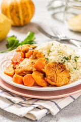 Chicken stew with pumpkin, carrots, tomatoes, spices and garlic, served with couscous on a ceramic...