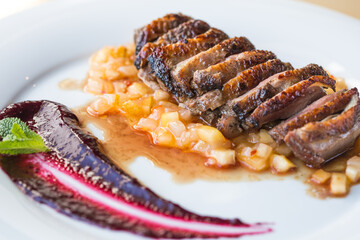 orange duck meal on the side. White plate.