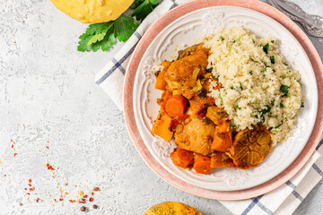 Chicken stew with pumpkin, carrots, tomatoes, spices and garlic, served with couscous on a ceramic...