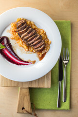 orange duck meal on the side. White plate.