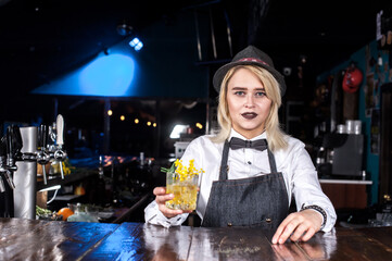 Girl bartender makes a cocktail in the pothouse