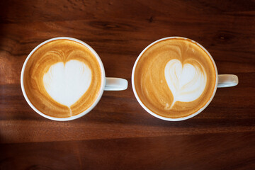 Cup of hot latte art coffee on wooden table
