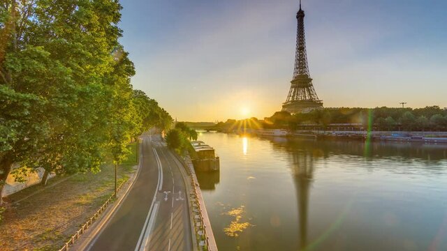 Eiffel Tower and the Seine river at Sunrise timelapse, Paris, France. Morning view from Bir-Hakeim bridge with reflections on water and traffic on the street