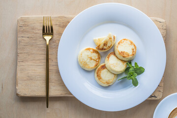 Sweet Cottage cheese pancakes on plate. Russian syrniki, ricotta fritters or curd fritters.
