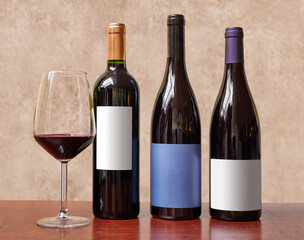 Three bottles of wine and glass of red wine