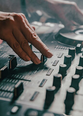 DJ Hands creating and regulating music on dj console mixer in concert nightclub stage