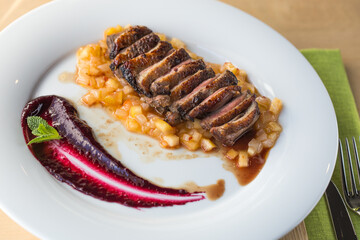 orange duck meal on the side. White plate.