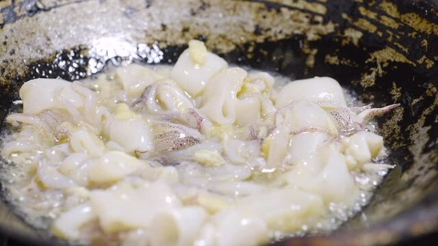 Squit get stir-fried in a pan with garlic and oil. Seafood and asian menu. 