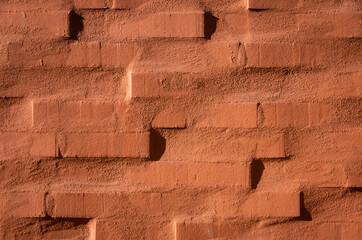 Red plastered brick wall as texture or background
