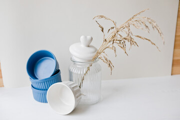 Set of ceramic dishes: small plates and glass jar on wooden background