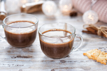 A cup of hot chocolate with cookies on the wooden table
