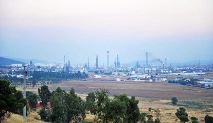 Refinería de petróleo y planta de la industria petroquímica en Puertollano con humos y niebla,...