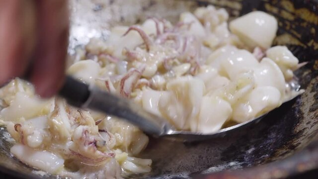 Squit get stir-fried in a pan with garlic and oil. Seafood and asian menu. 