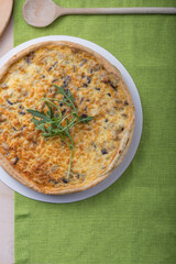 Traditional French Quiche with cheese, spinach and chicken. Quiche lorraine. French cuisine. Top view. Light wooden background