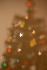 Star shaped bokeh on the Christmas tree. Defocused Christmas background.