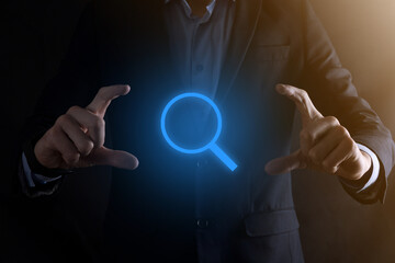 Businessman, man hold in hand magnifying glass icon.business, technology and internet concept