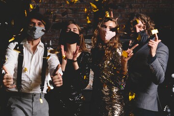 Enjoying amazing party. Corona virus pandemic. Group of beautiful young people in protective...