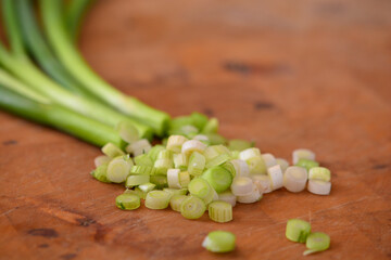 closeup of sliced spring onions on wooden background