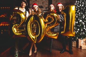Fototapeta na wymiar Party, people and new year holidays concept - women and men celebrating new years eve 2021