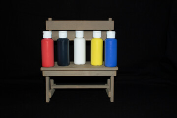 five primary colors of acrylic paint on a bench