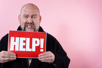 Studio photo of a crying man holding a red sign with the work HELP.