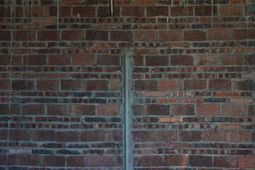 A room in a rough house under construction, with a red brick concrete structure