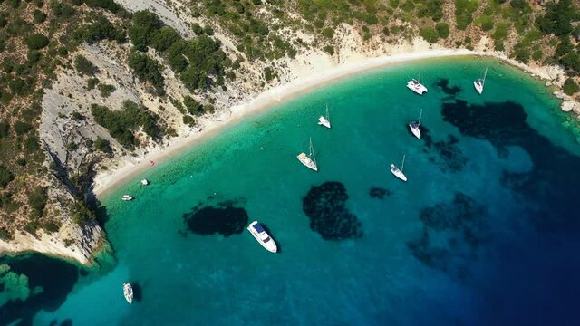 Aerial drone video of turquoise paradise sandy beach and bay of Filatro a safe sail boat anchorage in Ithaki or Ithaca island, Ionian, Greece