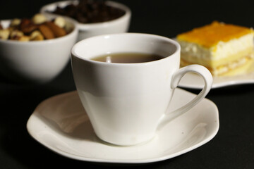 A cup of coffee with milk and coffee beans on a glass table. The concept of home comfort and warmth.