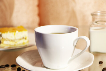  The concept of home comfort and warmth. On the table, a cup of coffee and a cake against a background of pink curtains.