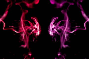 multicolored smoke of pink and red colors on a black isolated background. blur stock image